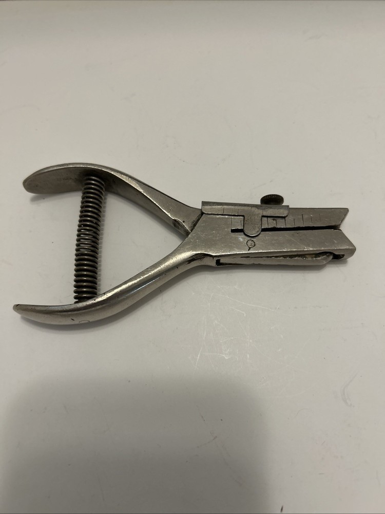 Vintage hole punch with spring handle action and adjustable punch depth guide