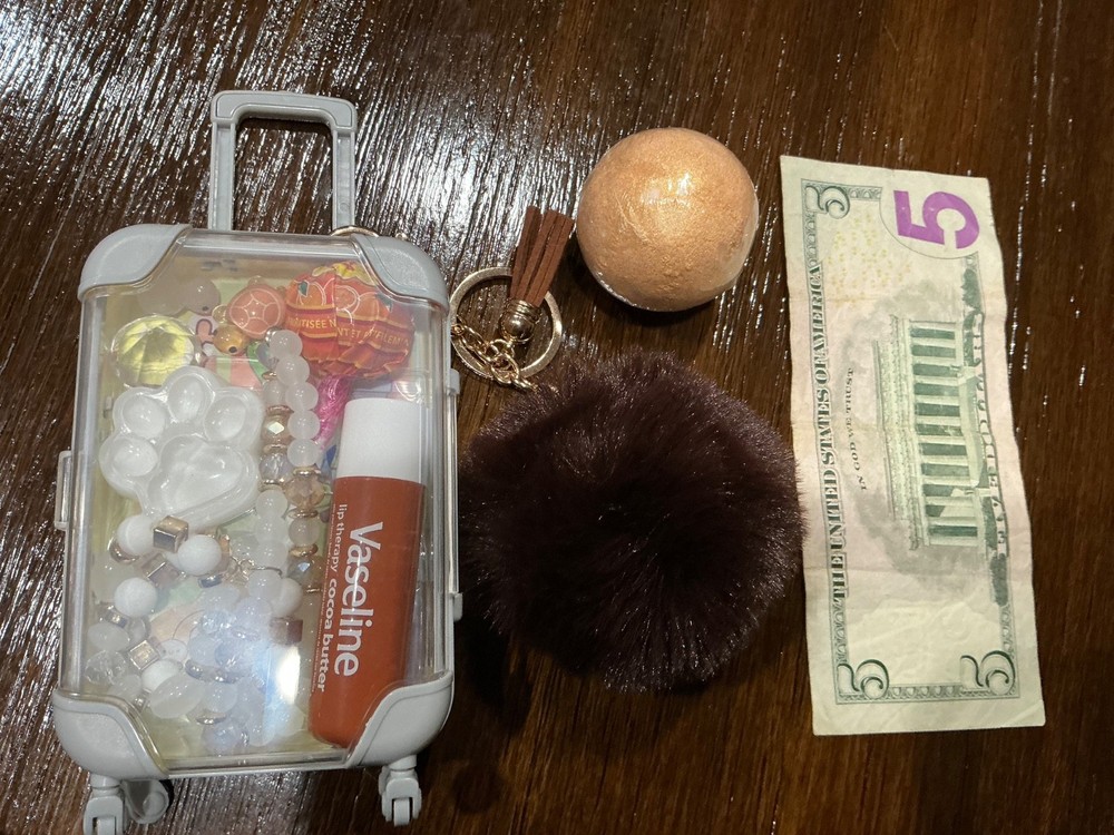 cute mini yellow suitcase with various trinkets inside