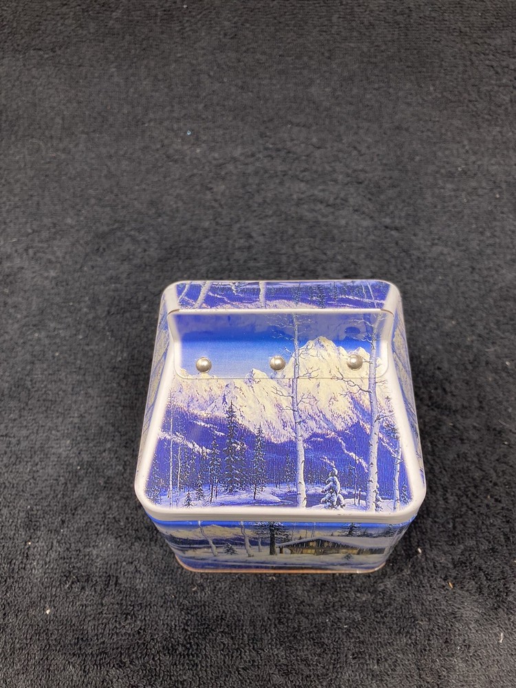 Winter mountain cabin scene tin