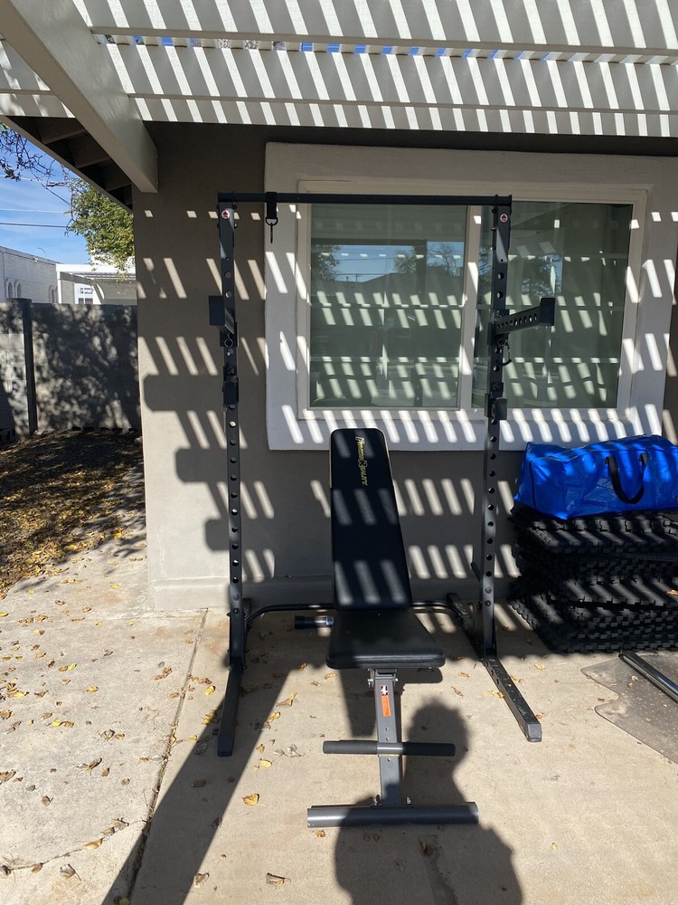 Squat Rack With Bench, Weights, Two Barbells, And A Rowing Machine