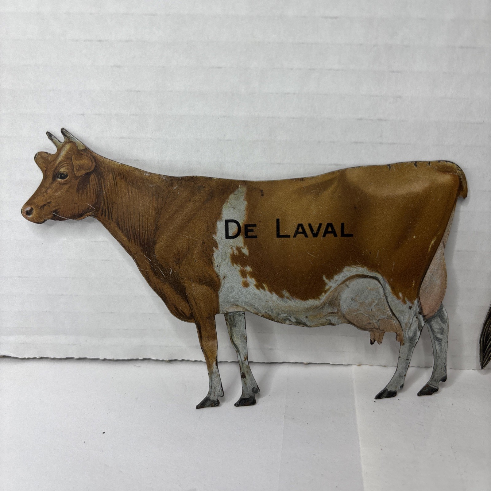 Pair of Antique DeLaval tin die cut cow and calf advertising cream separator ads