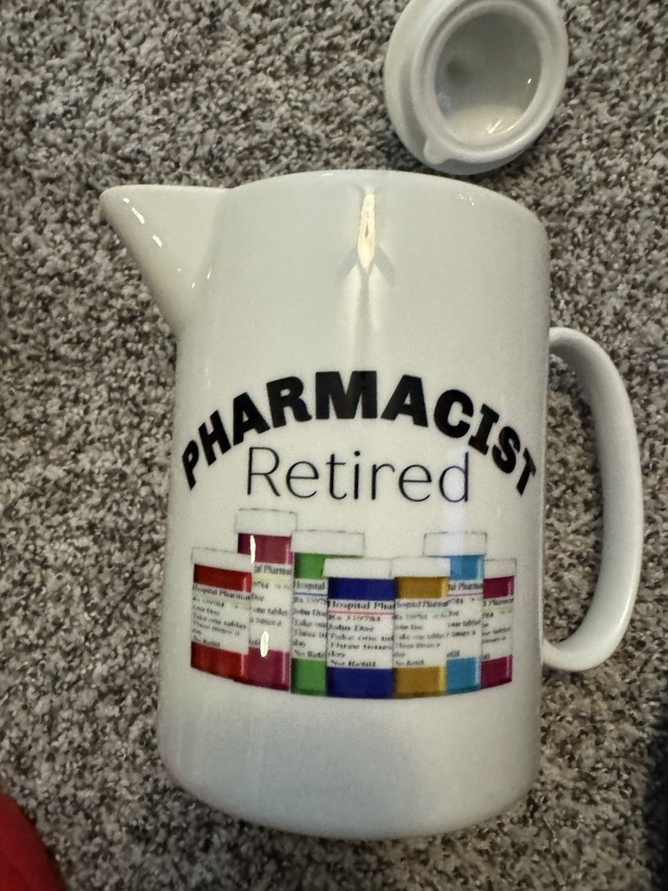 white ceramic teapot with a "Retired Pharmacist" design.
