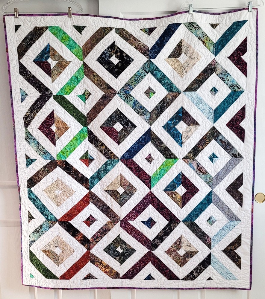 Hand made 55" X 62" Quilt In multiple batiks, purple batik back. Patchwork