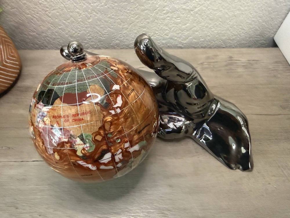 hand holding gemstone globe decor