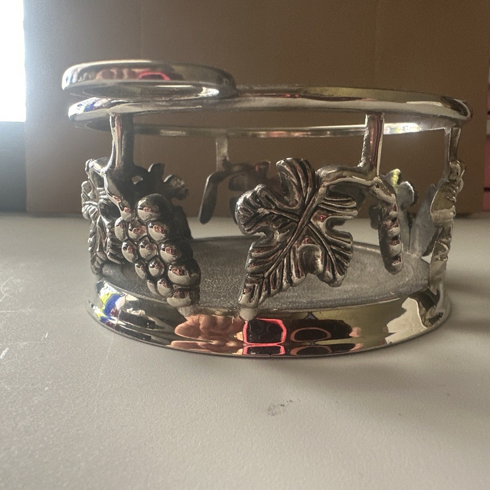 vintage, silver-plated wine bottle coaster featuring intricate grapevine pattern
