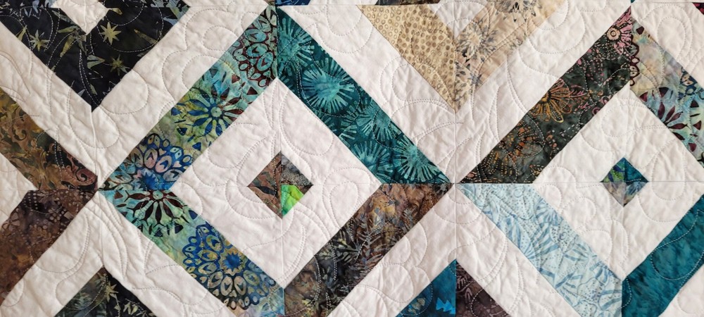 Hand made 55" X 62" Quilt In multiple batiks, purple batik back. Patchwork