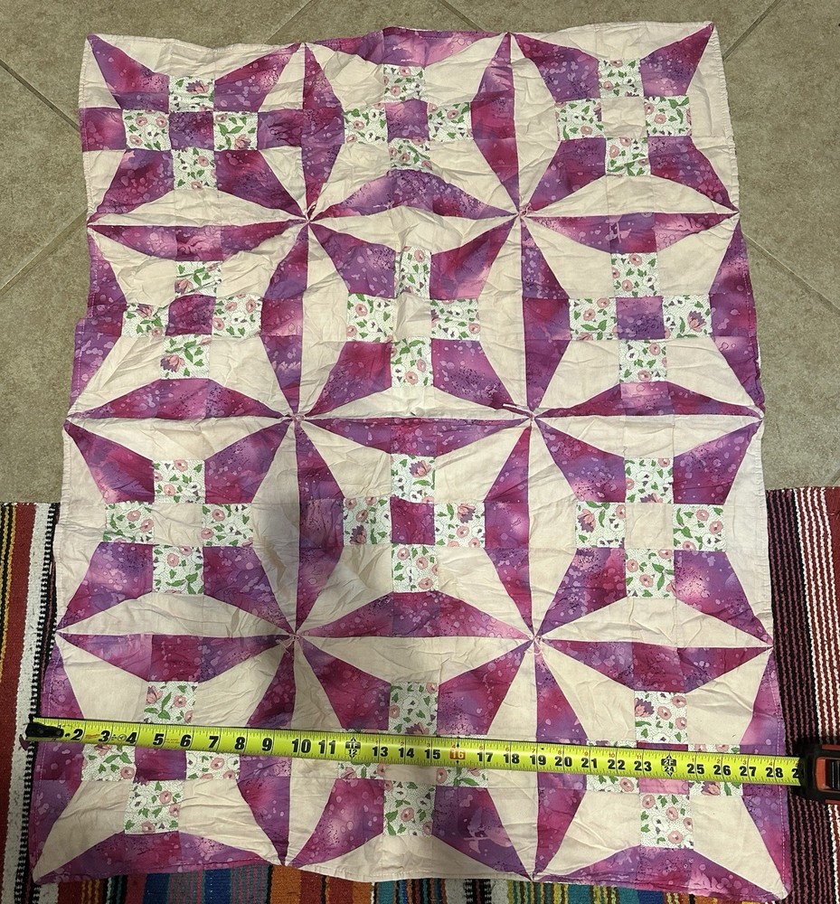 Handmade floral diamond pattern quilt with a multi-layered border.