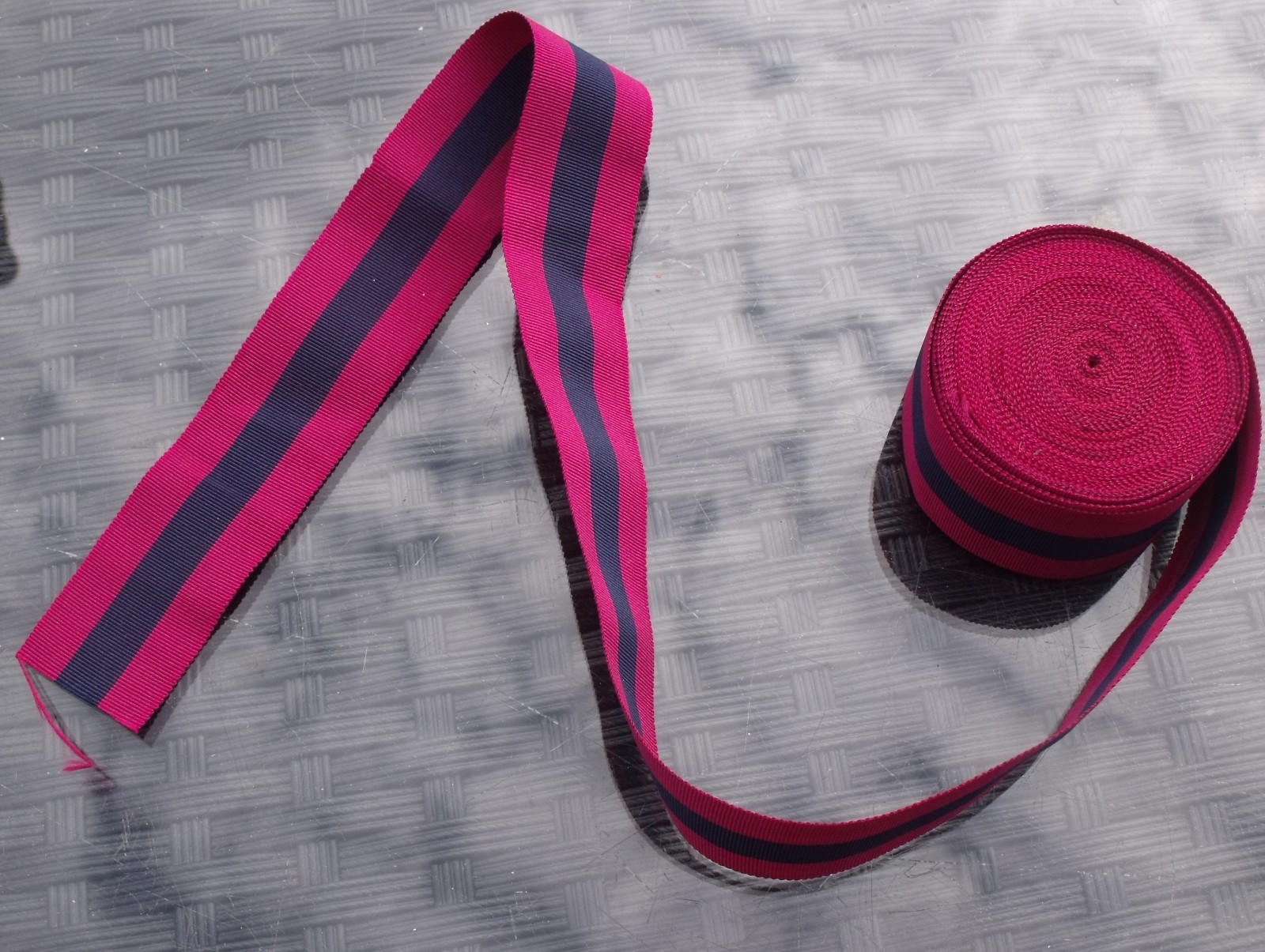 A 40 INCH LENGTH OF UNUSED OLD STOCK SILK DCM MEDAL RIBBON.