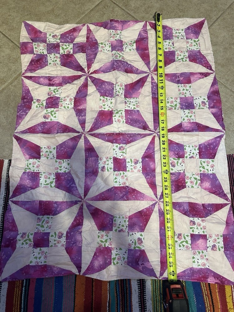Handmade floral diamond pattern quilt with a multi-layered border.